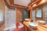 This stunning bathroom features a rustic design with wooden paneling and a modern shower.