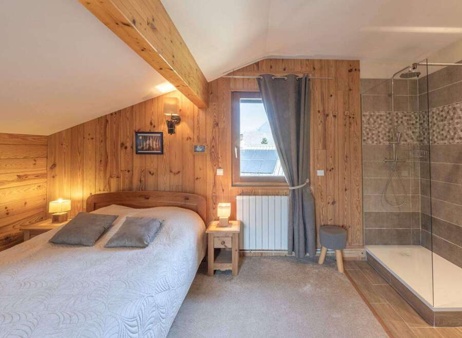 This cozy bedroom features beautiful wooden paneling and a comfortable bed, creating a warm and inviting atmosphere.