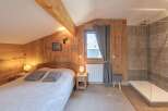 This cozy bedroom features beautiful wooden paneling and a comfortable bed, creating a warm and inviting atmosphere.