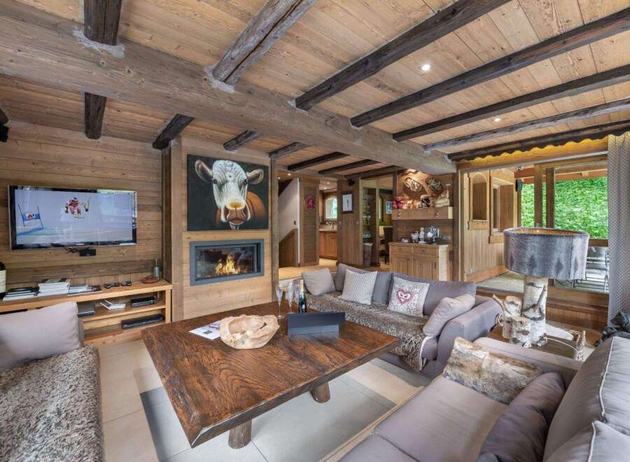 Experience rustic charm in this stunning chalet, featuring a cozy fireplace and a unique cow painting.