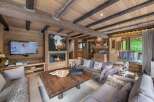 Experience rustic charm in this stunning chalet, featuring a cozy fireplace and a unique cow painting.