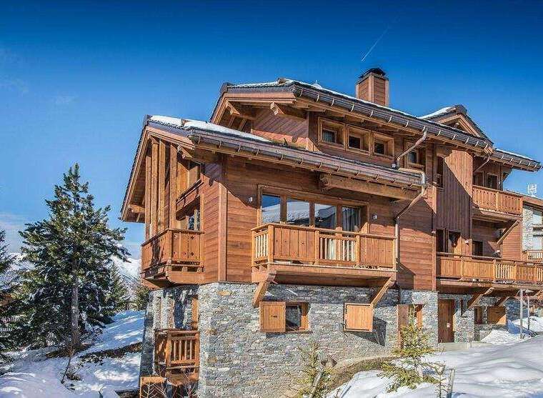 Discover the charm of this stunning wooden chalet nestled in a snowy landscape.