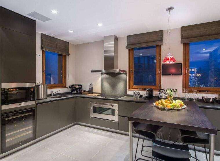 This modern kitchen boasts sleek, dark cabinetry and stainless steel appliances, creating a sophisticated and functional space.