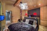 Experience luxury in this stunning bedroom featuring a plush velvet bedspread and elegant wooden accents.