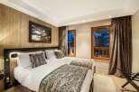Experience luxury mountain living in this elegantly appointed bedroom featuring two comfortable twin beds, perfect for a restful night's sleep.