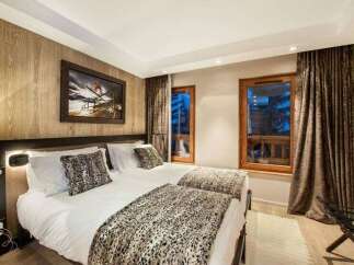Experience luxury mountain living in this elegantly appointed bedroom featuring two comfortable twin beds, perfect for a restful night's sleep.