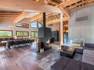 Experience luxury living in this stunning property, featuring a spacious open-plan design with exposed wooden beams and a cozy fireplace.