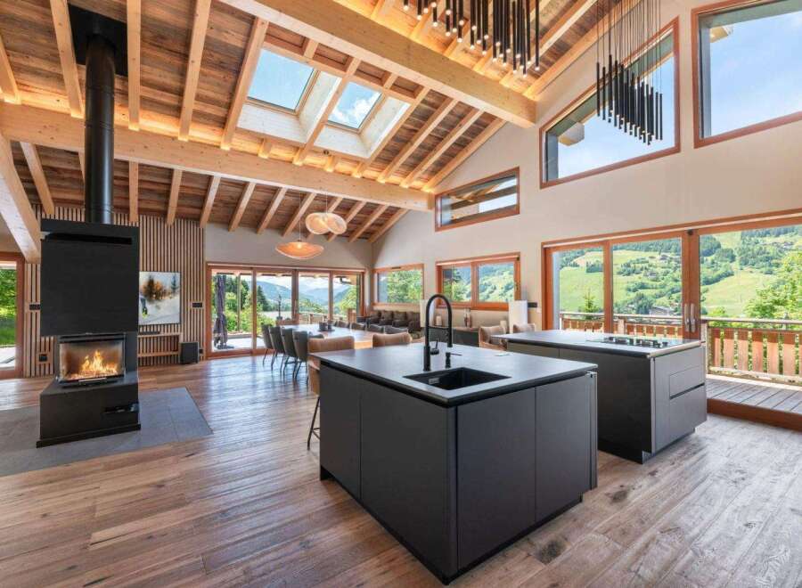 Experience luxury living in this stunning property, featuring a modern kitchen with sleek black countertops and a cozy fireplace.