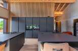 This modern kitchen boasts sleek, dark cabinetry and countertops, creating a sophisticated and contemporary aesthetic.