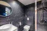 Step into luxury with this stunning bathroom featuring sleek black marble tiles.