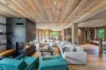 Experience luxury living in this stunning property featuring a modern fireplace, cozy seating areas, and a warm wooden interior.