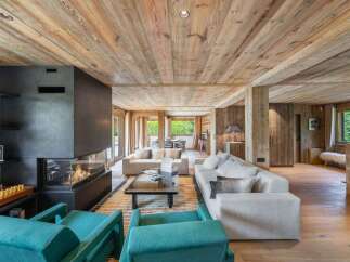 Experience luxury living in this stunning property featuring a modern fireplace, cozy seating areas, and a warm wooden interior.