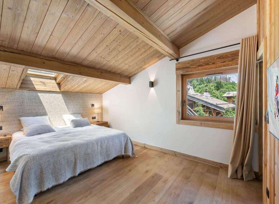 Experience the charm of this stunning bedroom, featuring a warm wooden ceiling and flooring that exudes rustic elegance.