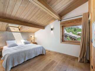Experience the charm of this stunning bedroom, featuring a warm wooden ceiling and flooring that exudes rustic elegance.