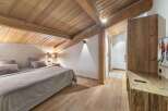 Experience the charm of this stunning bedroom, featuring a warm wooden ceiling and flooring that create a cozy ambiance.
