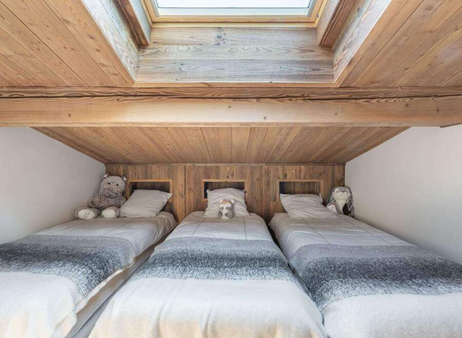 This cozy bedroom features three single beds, perfect for a family or guests.