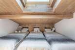 This cozy bedroom features three single beds, perfect for a family or guests.