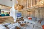 Experience luxury living in this stunning chalet, featuring a cozy living room with a modern fireplace and a comfortable seating area.