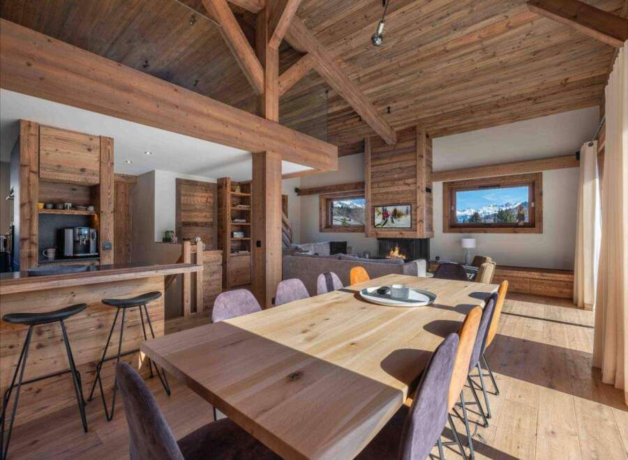 Experience luxury living in this stunning property, featuring a spacious dining area with a large wooden table and stylish chairs.