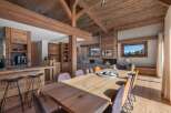 Experience luxury living in this stunning property, featuring a spacious dining area with a large wooden table and stylish chairs.