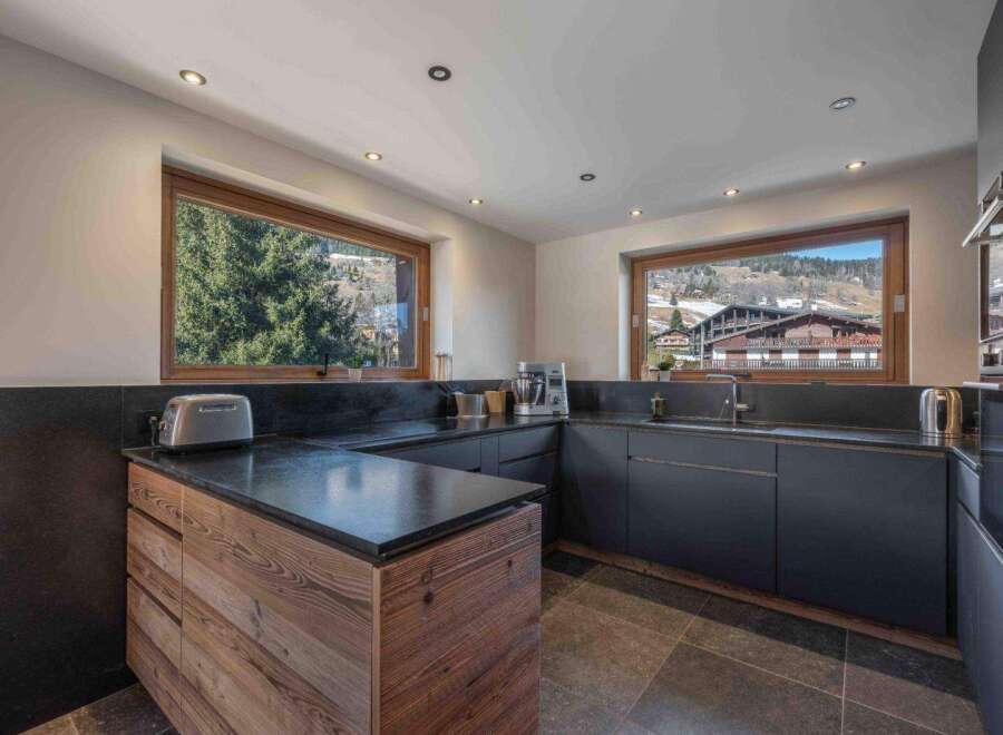 This stunning kitchen boasts a modern design with sleek black countertops and cabinetry, creating a sophisticated and functional space.