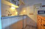 This cozy kitchen features a microwave, refrigerator, and stovetop, perfect for preparing meals.
