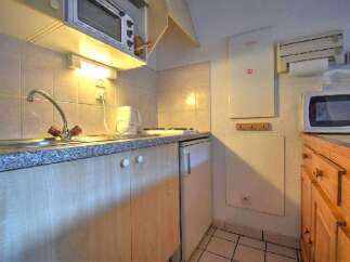 This cozy kitchen features a microwave, refrigerator, and stovetop, perfect for preparing meals.