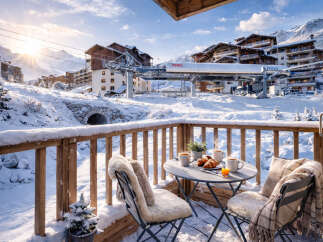 Enjoy breathtaking mountain views from this cozy ski chalet balcony.