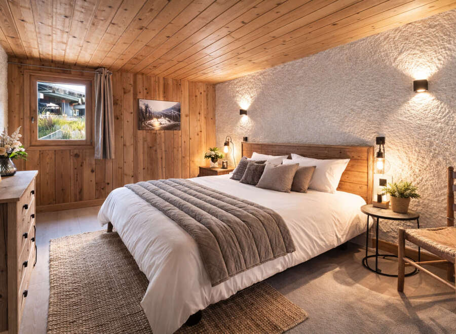 Experience rustic charm in this cozy bedroom! Featuring a wooden ceiling and walls, this space exudes warmth and comfort.