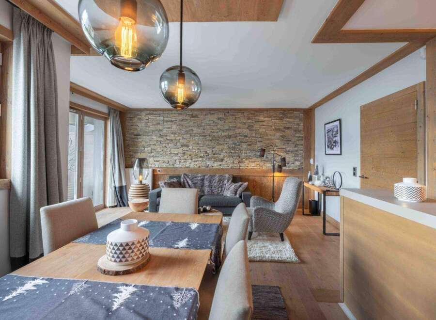 Experience luxury living in this stunning property, featuring a beautifully designed dining area with a wooden table and stylish chairs.
