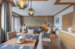 Experience luxury living in this stunning property, featuring a beautifully designed dining area with a wooden table and stylish chairs.