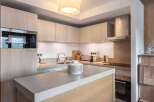 This modern kitchen boasts sleek cabinetry and a stylish island, perfect for culinary enthusiasts.
