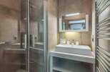 This modern bathroom features a sleek glass shower enclosure and a stylish vanity with a rectangular sink.