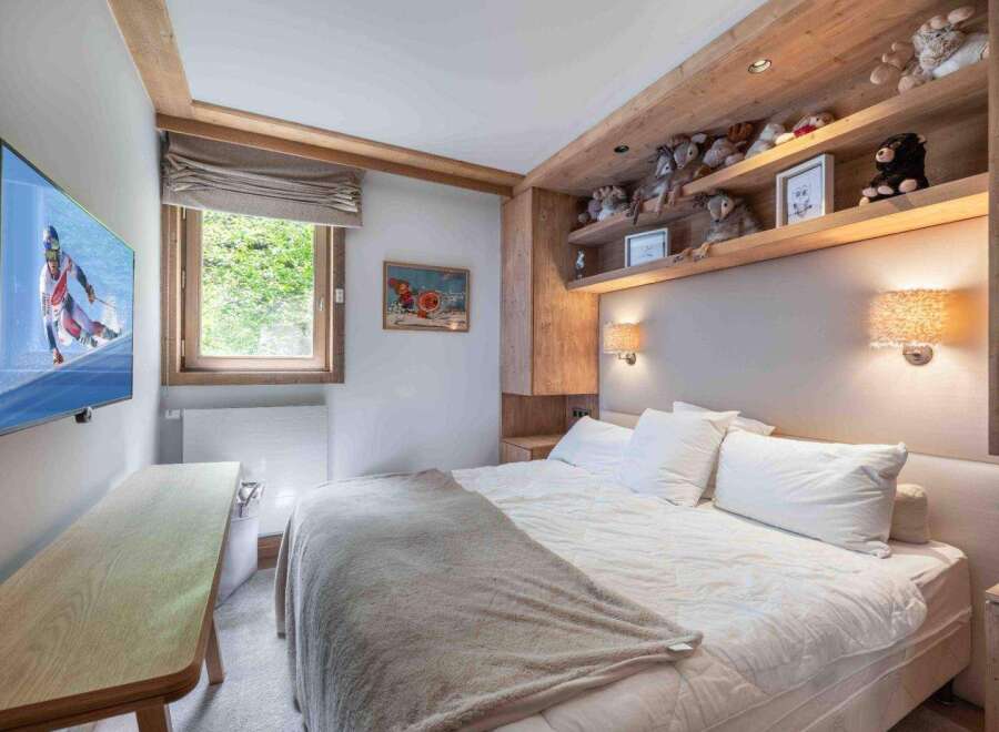 This cozy bedroom features a comfortable bed with plush pillows and a soft blanket, perfect for a relaxing retreat.