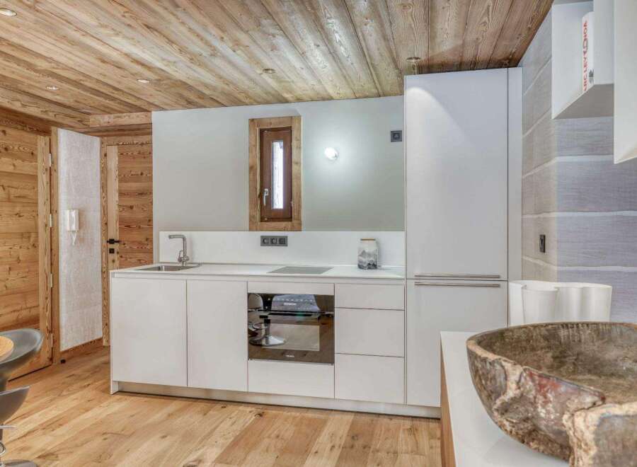 This stunning kitchen boasts a modern design with sleek white cabinetry and a built-in oven.