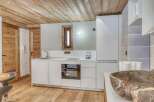 This stunning kitchen boasts a modern design with sleek white cabinetry and a built-in oven.