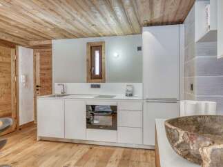This stunning kitchen boasts a modern design with sleek white cabinetry and a built-in oven.