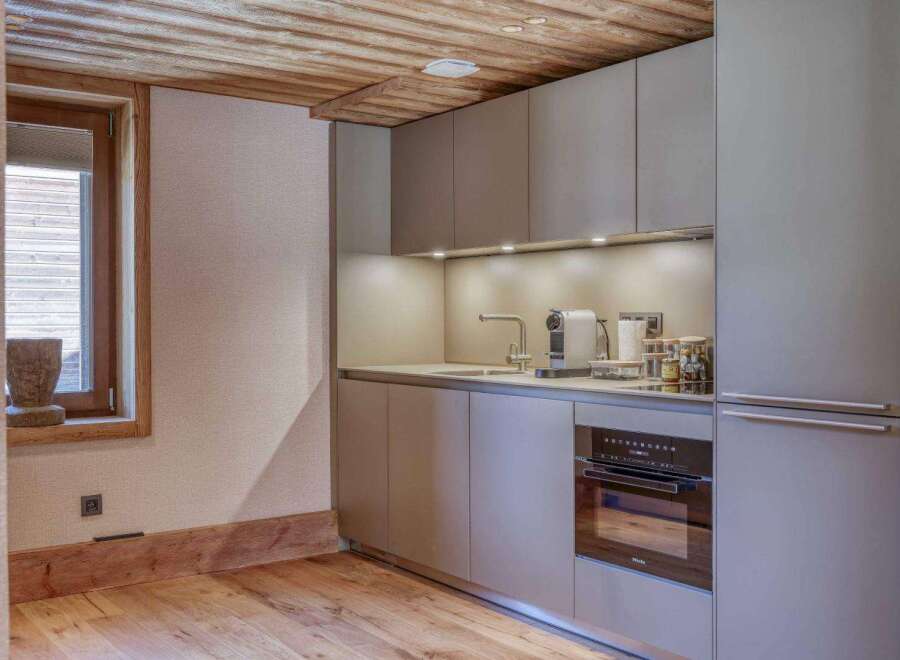 This modern kitchen boasts sleek cabinetry and a built-in oven, perfect for culinary enthusiasts.