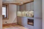 This modern kitchen boasts sleek cabinetry and a built-in oven, perfect for culinary enthusiasts.