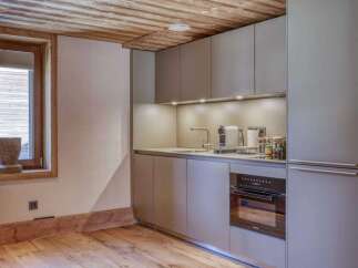 This modern kitchen boasts sleek cabinetry and a built-in oven, perfect for culinary enthusiasts.