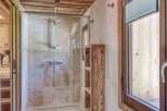 Step into luxury with this stunning bathroom featuring a sleek glass shower enclosure and elegant wooden accents.