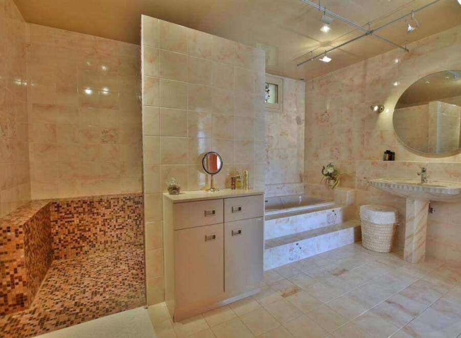 Step into luxury with this stunning bathroom featuring exquisite tile work and a spa-like ambiance.