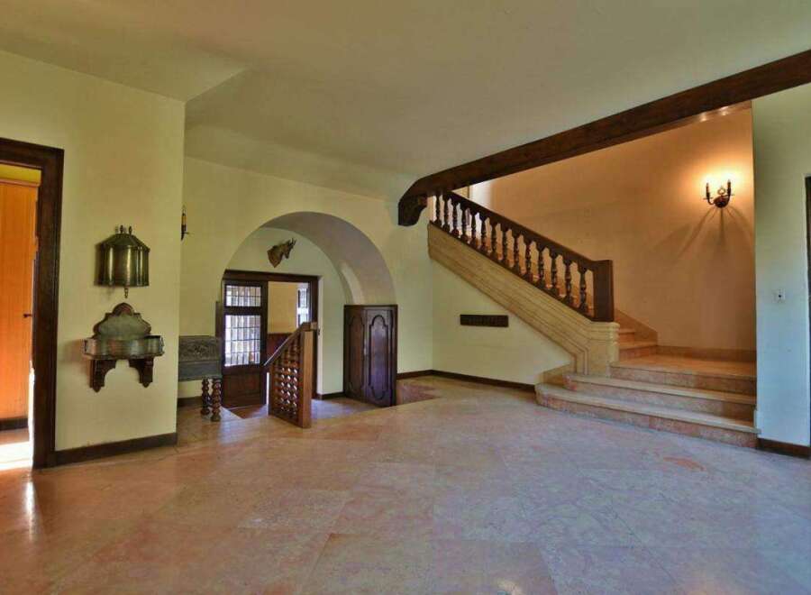 Step into luxury with this stunning property featuring a grand staircase and elegant architectural details.