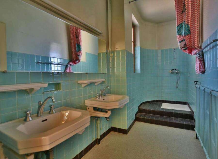 Step back in time with this charming bathroom! Featuring retro turquoise tiles, this space exudes vintage appeal.