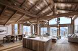 Experience luxury living in this stunning chalet, boasting a warm and inviting interior with exposed wooden beams and a cozy fireplace.
