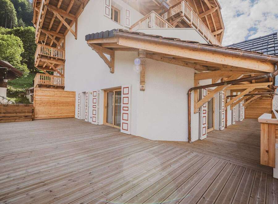 This stunning property showcases exquisite wooden architecture and a spacious wooden deck, perfect for enjoying the outdoors.