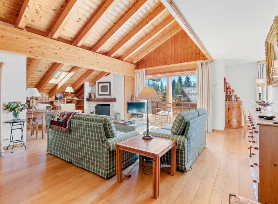Experience the charm of this stunning living room, featuring a vaulted wooden ceiling and a cozy fireplace.