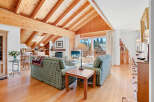 Experience the charm of this stunning living room, featuring a vaulted wooden ceiling and a cozy fireplace.