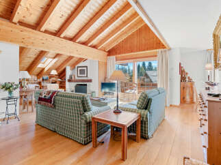 Experience the charm of this stunning living room, featuring a vaulted wooden ceiling and a cozy fireplace.