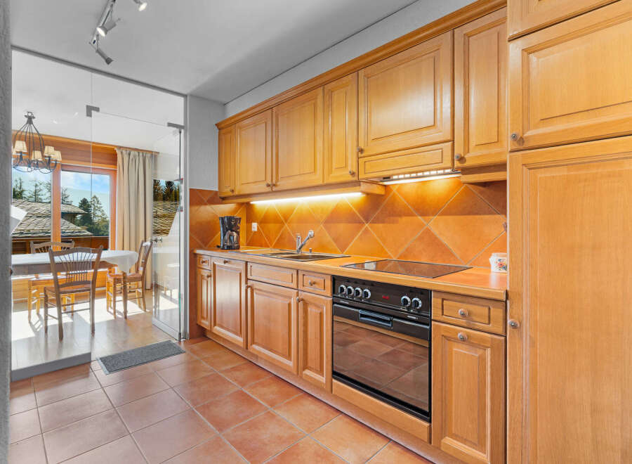 Discover this charming kitchen with warm wooden cabinetry and a modern cooktop.
